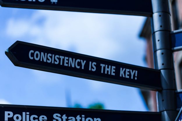 Handwriting Text Writing Consistency Is The Key. Concept Meaning A road sign points to the left and says Consistency is the Key!