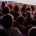 The audience in the theater watching a play. The audience in the hall: adults and children.