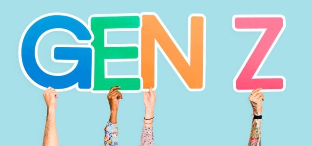 Four hands hold up letter signs spelling out “GEN Z.”