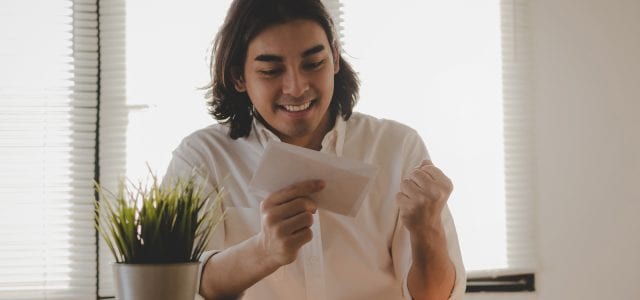 A young man is excited to receive a birthday card from his favorite business.