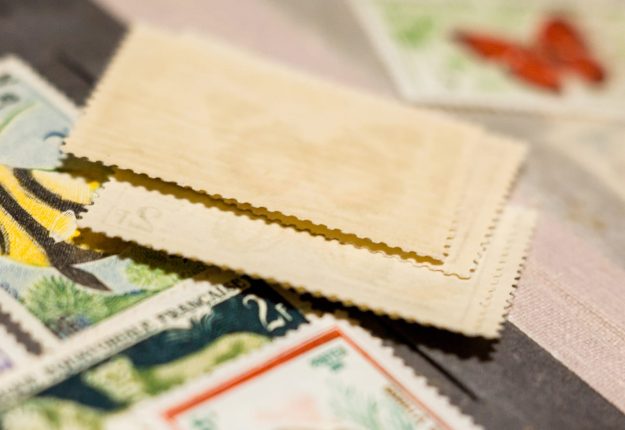 Kyiv, Ukraine –  March 24, 2019: Pile Of Stamps In The Stamp Alb A small stack of stamps with various artworks are ready to be attached to letters and sent on their way.