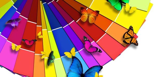 A bright color wheel sits with butterflies of matching colors flying above it.