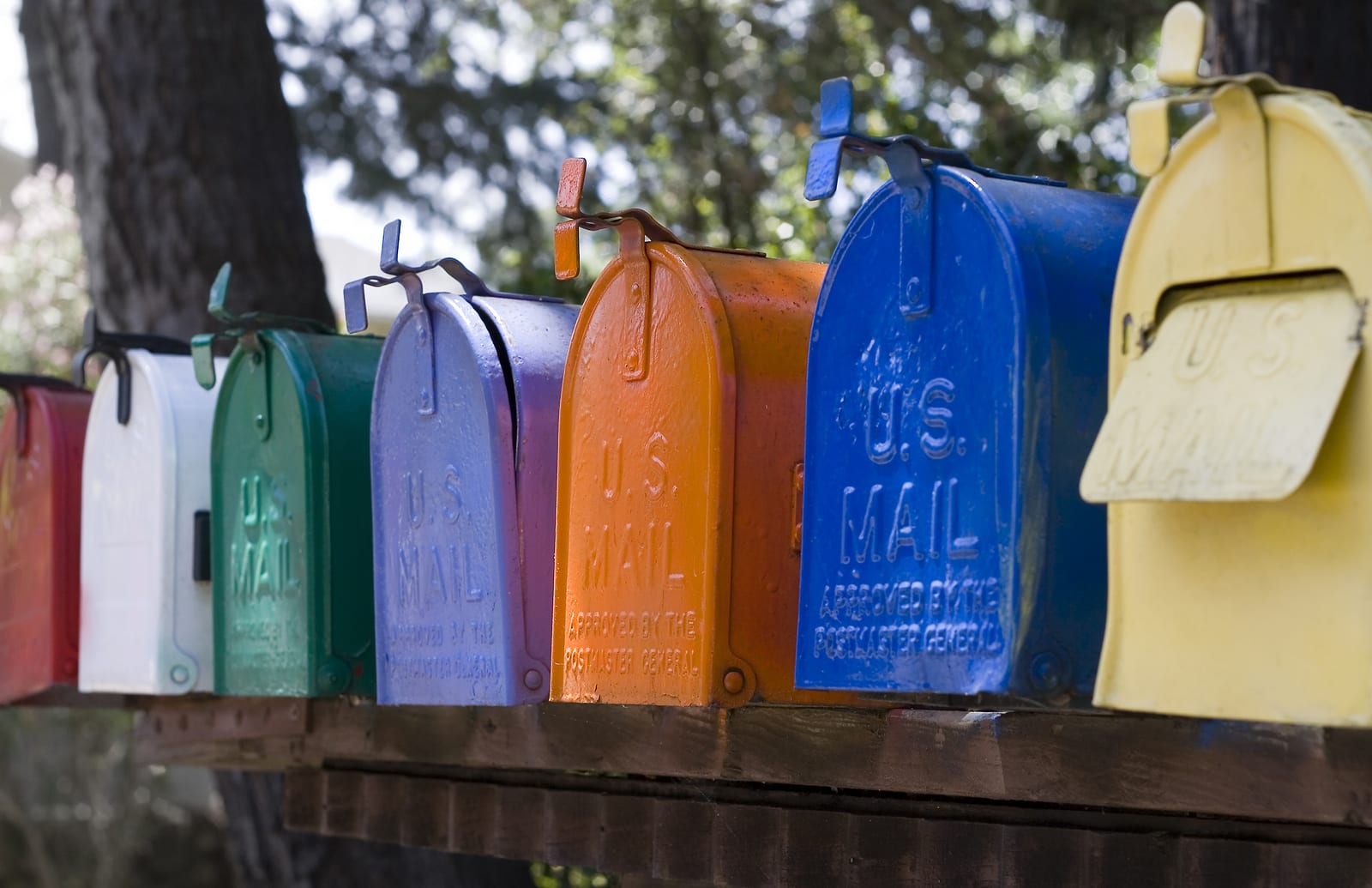 A row of multicolor mail mailboxes all have U.S. Mail stamped on the front.