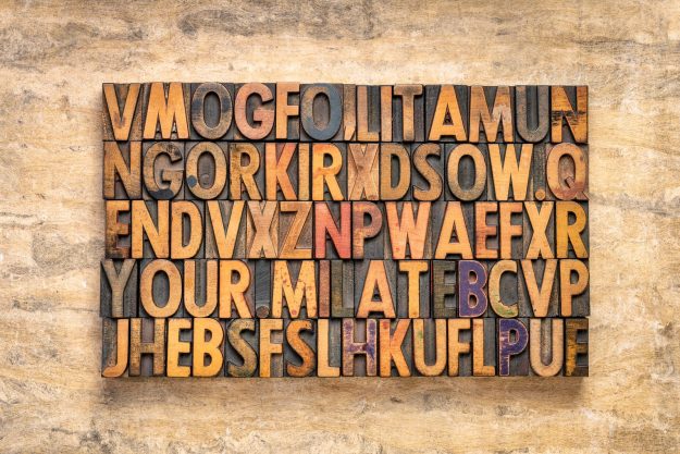 rectangular block of random vintage letterpress wood type printi rectangular block of random vintage letterpress wood type printing blocks against textured bark paper