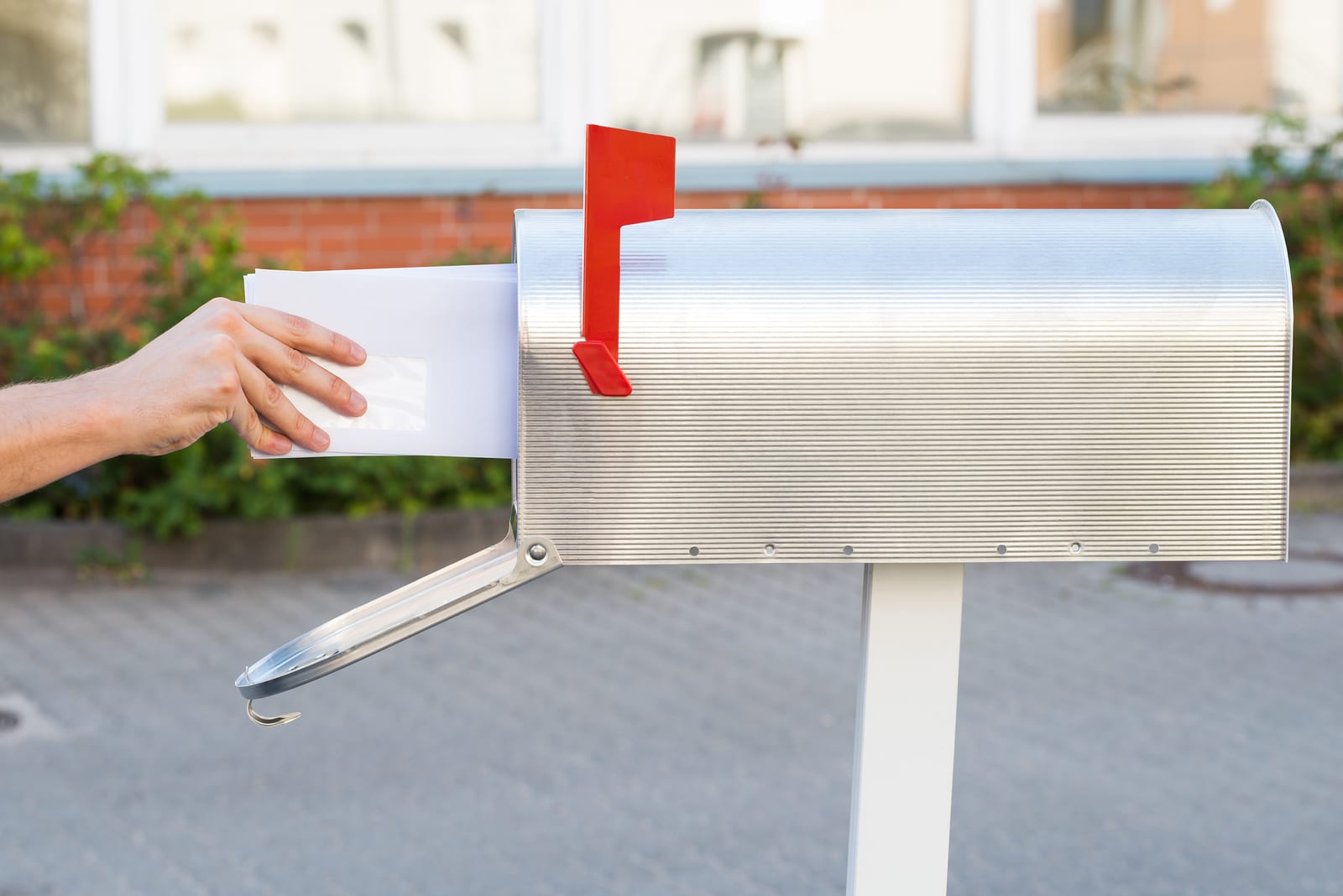 Close-up Of Person Removing Yellow Letters From Mailbox