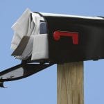 Black Mailbox stuffed with junk mail on a blue background